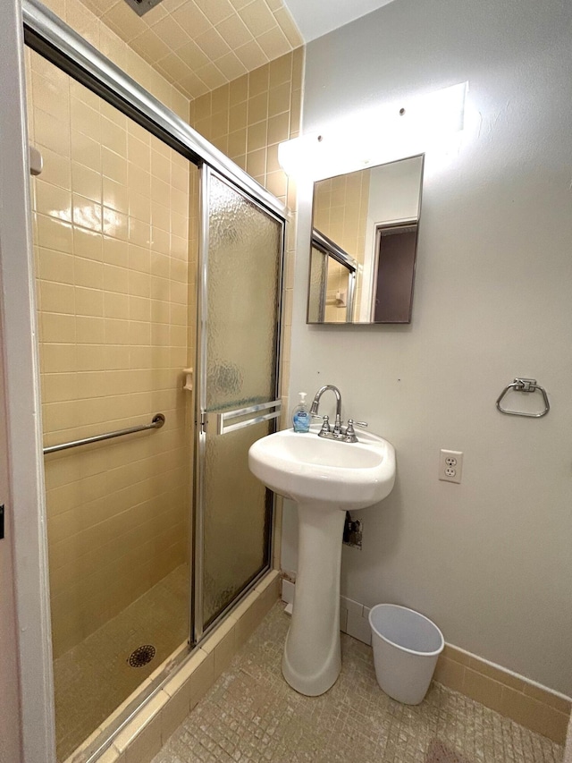 bathroom featuring walk in shower, sink, and tile patterned flooring