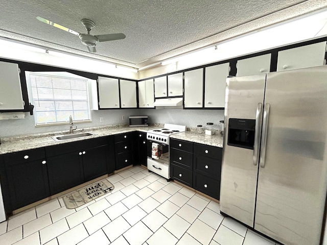 kitchen with a textured ceiling, light tile patterned floors, stainless steel appliances, sink, and ceiling fan