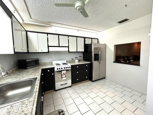 kitchen featuring light tile patterned floors, appliances with stainless steel finishes, sink, ceiling fan, and a textured ceiling