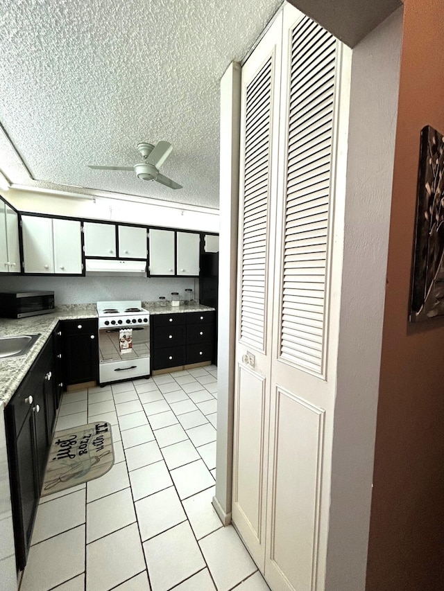 kitchen with a textured ceiling, light tile patterned floors, white electric range, ceiling fan, and light stone counters