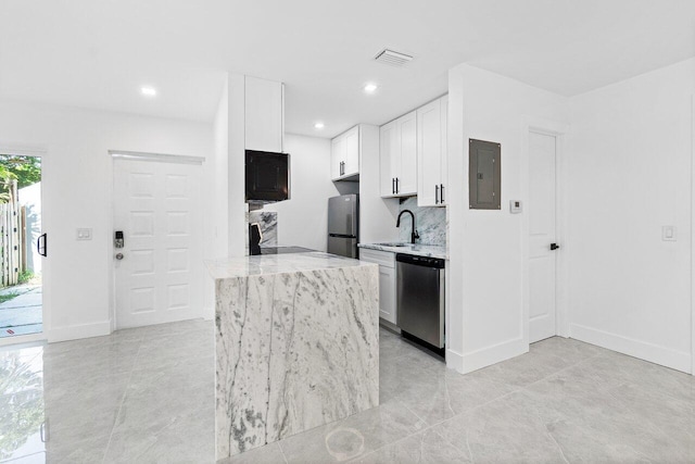 kitchen featuring light tile patterned floors, stainless steel appliances, sink, white cabinetry, and electric panel