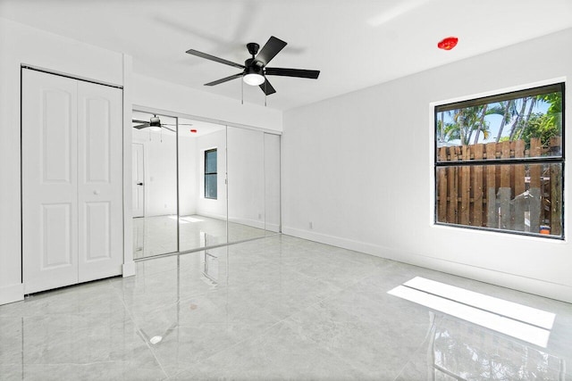 unfurnished bedroom featuring two closets, ceiling fan, and light tile patterned flooring