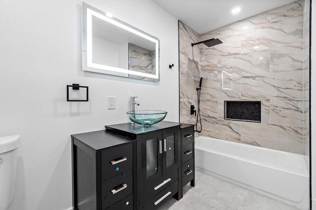 full bathroom featuring tiled shower / bath, vanity, toilet, and tile patterned floors