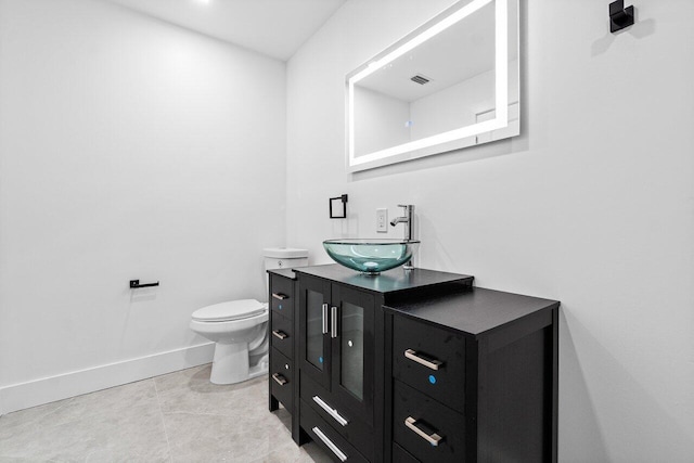 bathroom featuring vanity, toilet, and tile patterned flooring