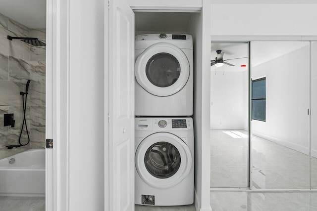 laundry room featuring ceiling fan and stacked washer and dryer