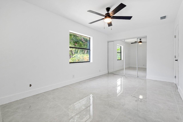 empty room with ceiling fan and light tile patterned flooring