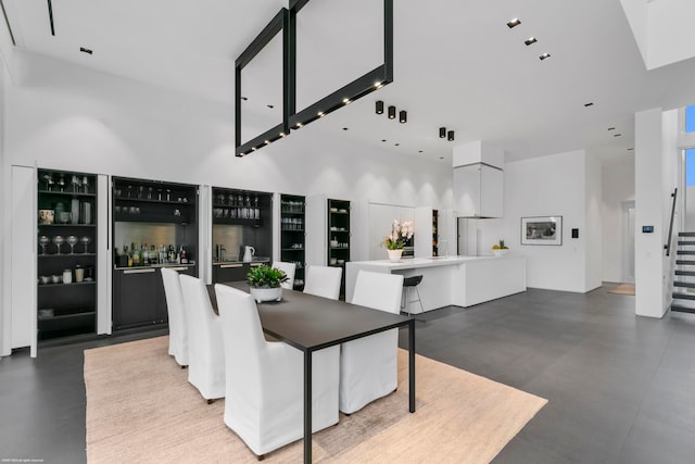 dining space featuring a high ceiling and bar