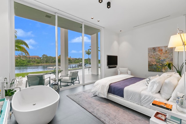 bedroom with access to exterior, a wall of windows, and concrete flooring