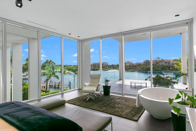 interior space featuring a water view, a wall of windows, tile patterned flooring, and access to exterior