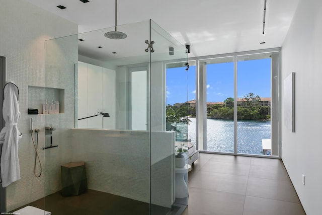 bathroom featuring a water view, floor to ceiling windows, and a shower