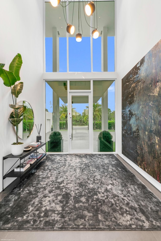 unfurnished living room with a towering ceiling and a notable chandelier