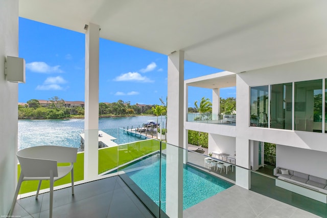 view of pool with a yard, a water view, and a patio area