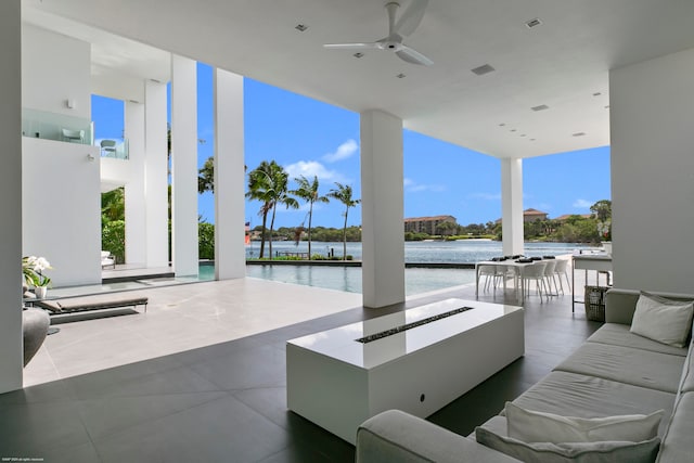 view of patio featuring an outdoor living space, ceiling fan, and a water view