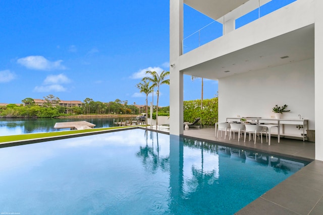 view of pool featuring a patio and a water view