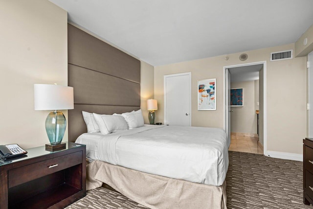 bedroom with carpet floors, visible vents, and baseboards