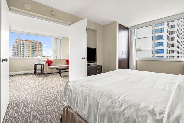 bedroom featuring a view of city, carpet, and baseboards