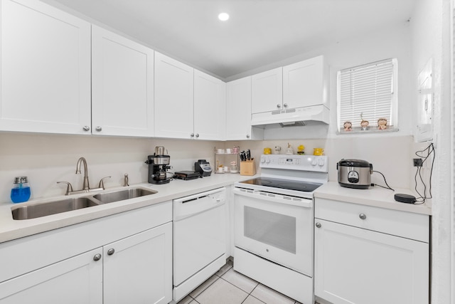 kitchen with white appliances, white cabinetry, sink, and light tile patterned flooring