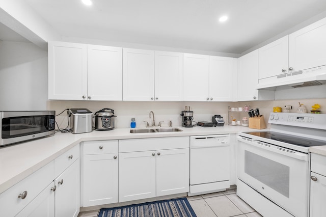 kitchen featuring white appliances, light tile patterned flooring, sink, and white cabinets