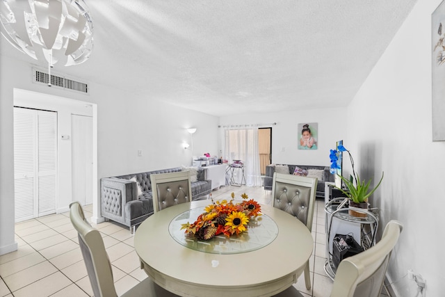 tiled dining area with a textured ceiling