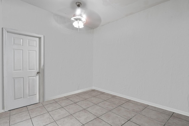 empty room with ceiling fan and light tile patterned floors