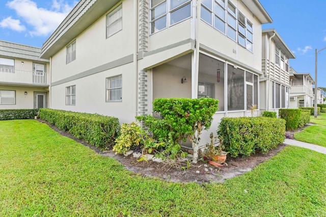 262 Monaco F, Delray Beach, FL 33446 - view of home's exterior featuring stucco siding and a yard