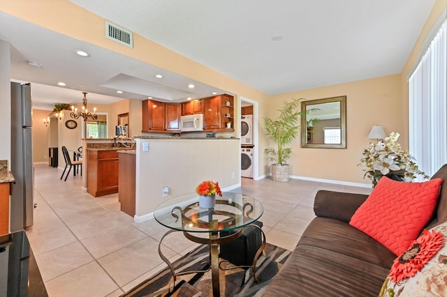 262 Monaco F, Delray Beach, FL 33446 - living room featuring stacked washer and clothes dryer, light tile patterned floors, a chandelier, baseboards, and recessed lighting