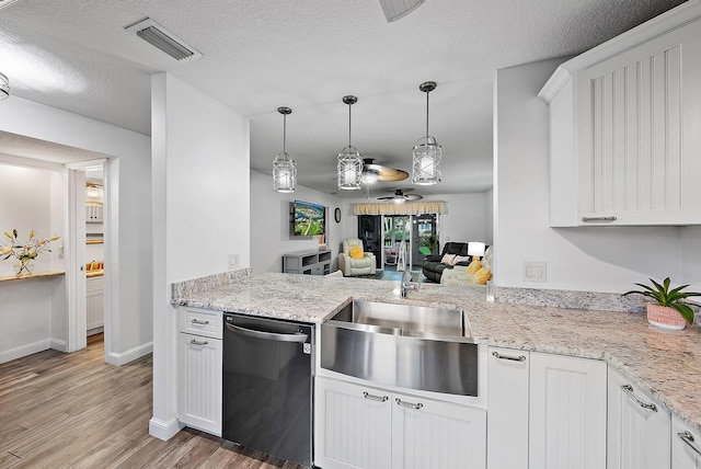 kitchen featuring a textured ceiling, decorative light fixtures, dishwasher, wood-type flooring, and white cabinets