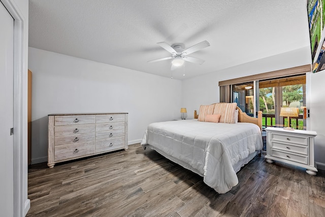 bedroom with dark wood-type flooring, ceiling fan, and a textured ceiling