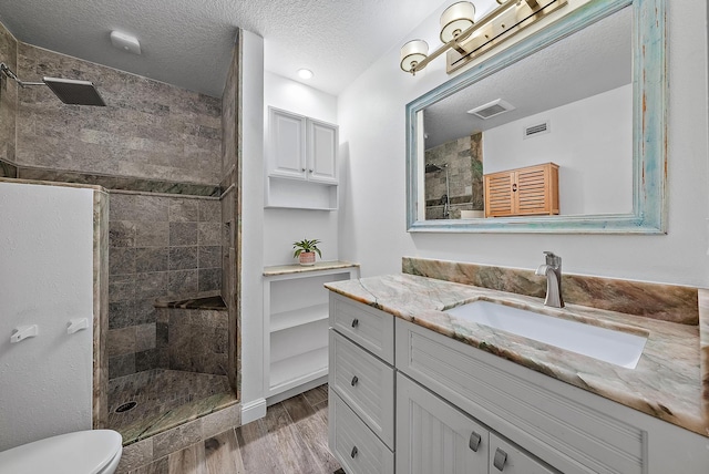 bathroom featuring vanity, hardwood / wood-style flooring, and tiled shower