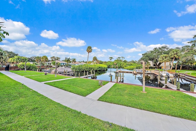 view of dock with a yard and a water view