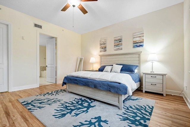 bedroom with light wood-type flooring, ceiling fan, and connected bathroom