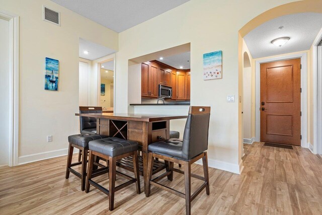 dining area featuring a textured ceiling and light hardwood / wood-style floors