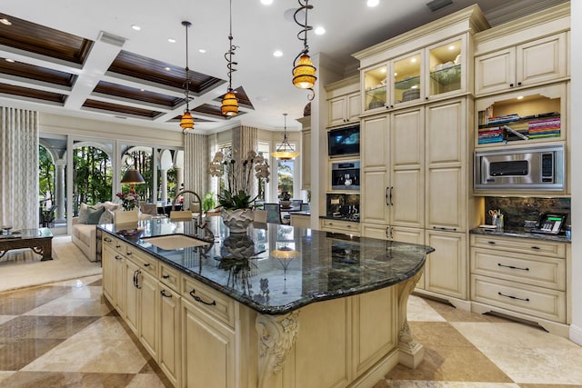 kitchen featuring stainless steel appliances, backsplash, cream cabinets, a sink, and coffered ceiling