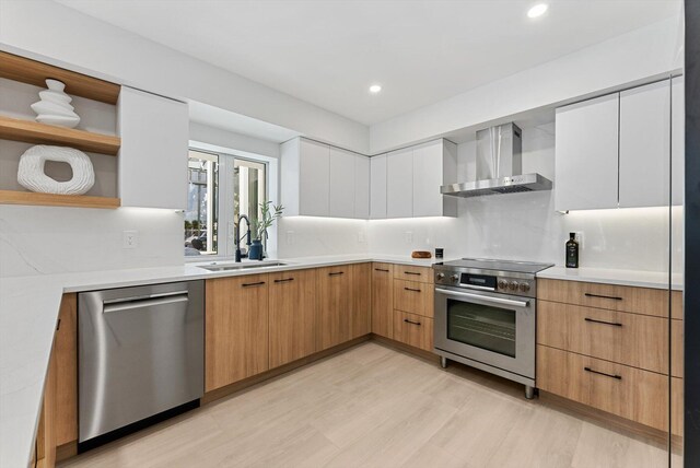 kitchen featuring backsplash, stainless steel appliances, sink, wall chimney range hood, and white cabinets