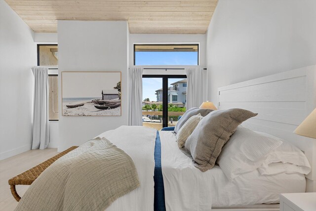 bedroom featuring vaulted ceiling, wooden ceiling, and access to outside