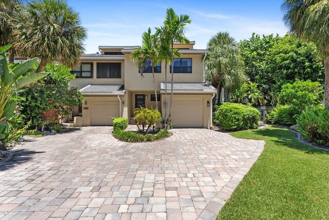 view of front of property featuring a garage and a front lawn