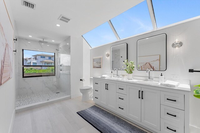 bathroom with a shower with shower door, toilet, vanity, and vaulted ceiling