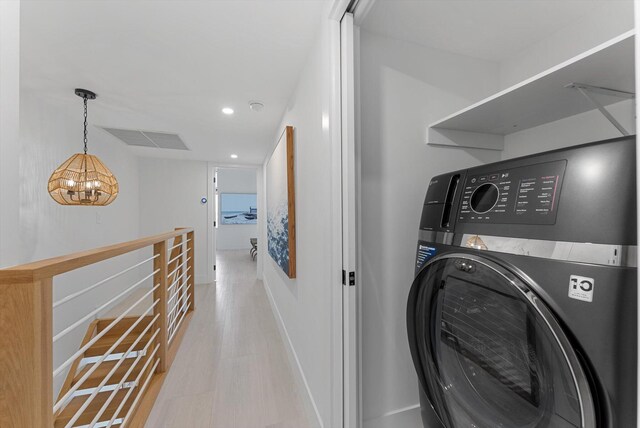 laundry room with washer / dryer and a chandelier