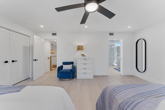 bedroom featuring ceiling fan, a closet, ensuite bathroom, and light hardwood / wood-style floors