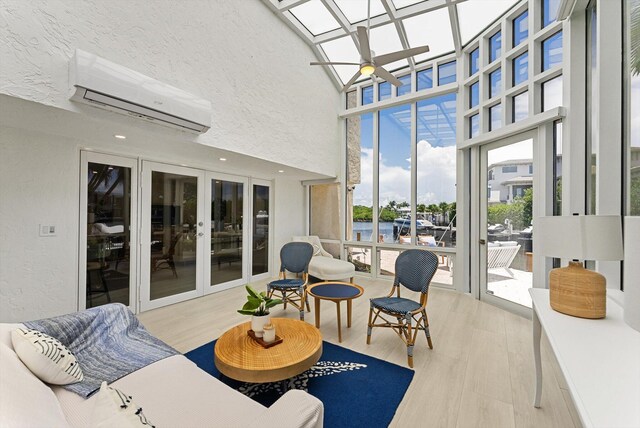 sunroom with a wall mounted air conditioner, a skylight, and ceiling fan