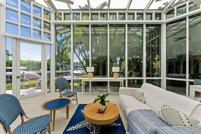 sunroom / solarium featuring a water view and ceiling fan