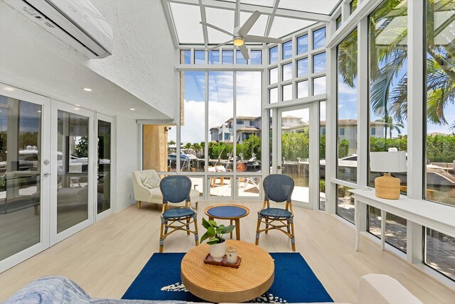 sunroom / solarium featuring a wall mounted AC, ceiling fan, and french doors