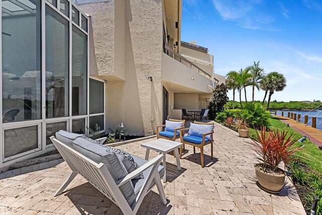 view of patio featuring a balcony, an outdoor hangout area, and a water view