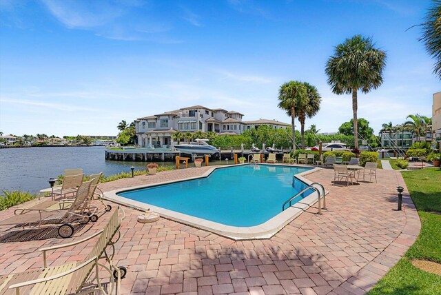 view of swimming pool with a patio area and a water view