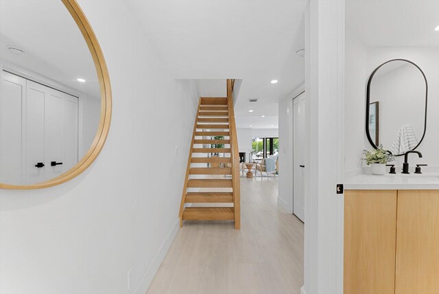 hallway featuring light hardwood / wood-style flooring and sink