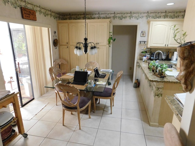 dining space with sink, light tile patterned floors, and a chandelier