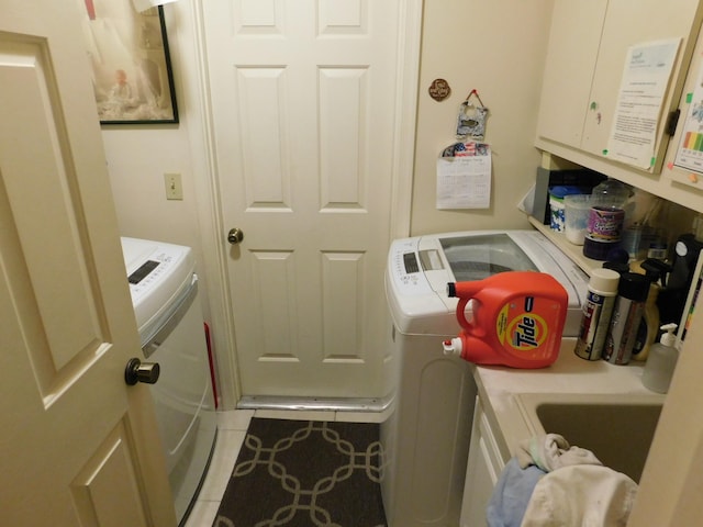 laundry room featuring washing machine and dryer and light tile patterned flooring