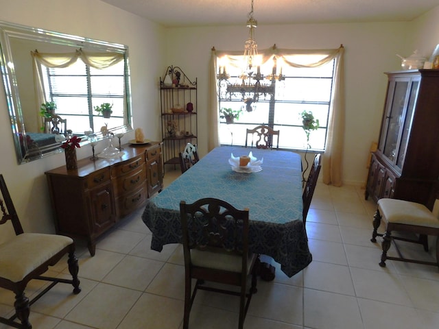 dining space with light tile patterned floors and an inviting chandelier