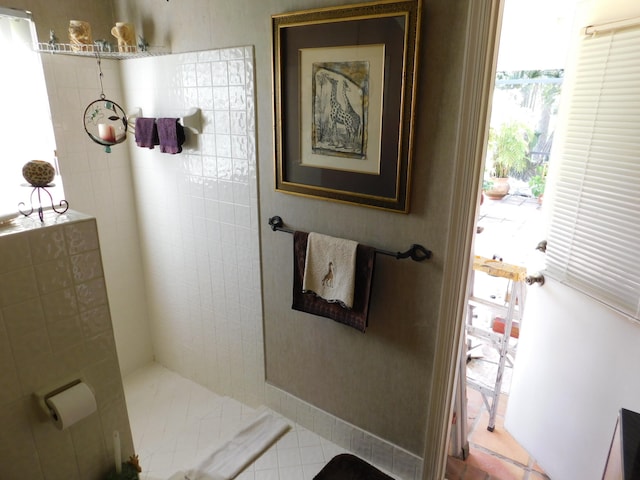 bathroom featuring tiled shower, tile patterned floors, and plenty of natural light