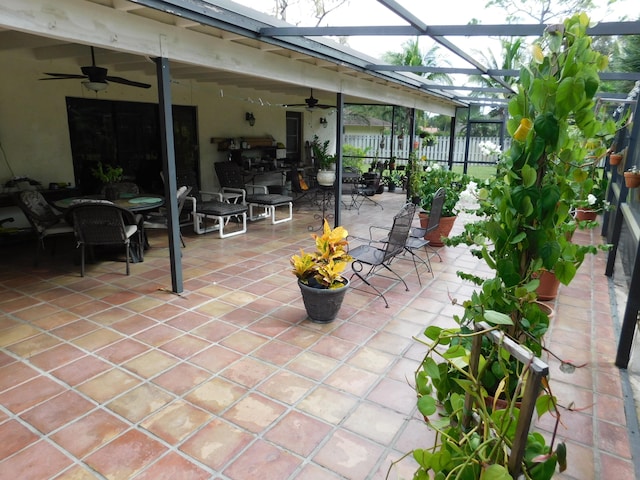 view of patio with ceiling fan and glass enclosure